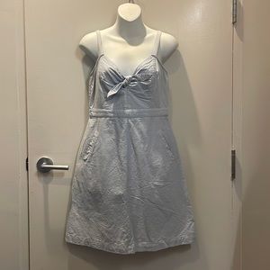 blue sundress with tie detail and pockets. Back zip. Size medium runs small.